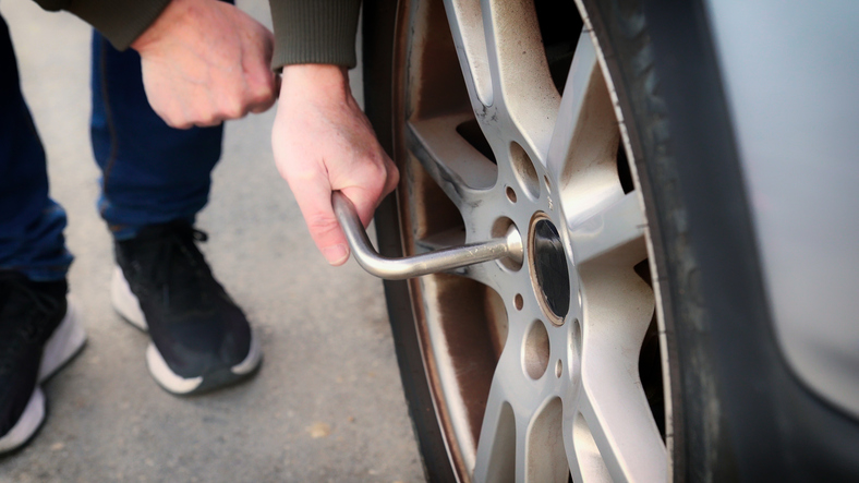 changing flat tire on car
