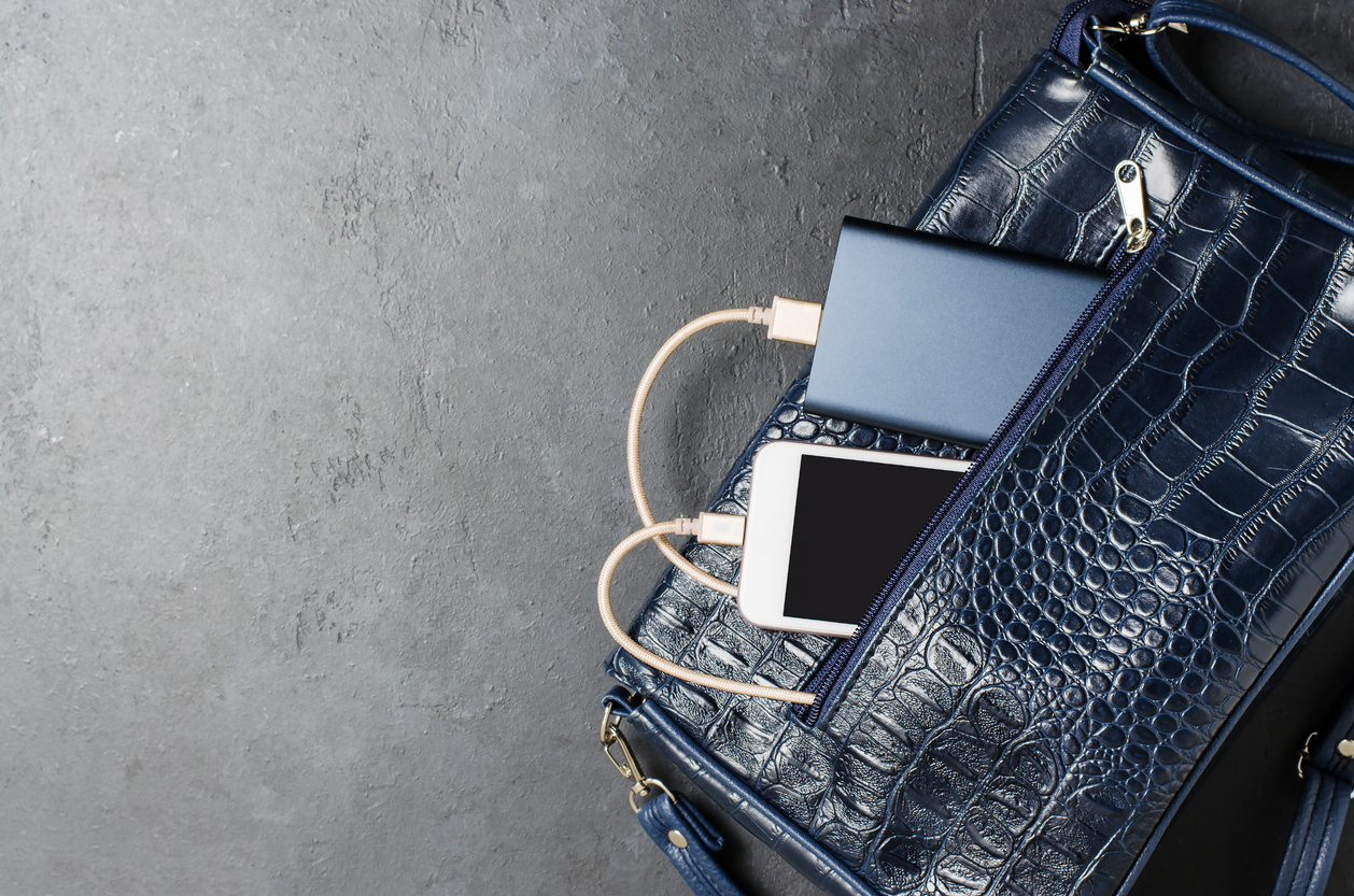 Blue power bank and a smartphone in the women's bag